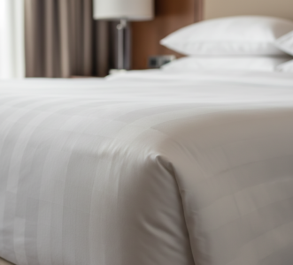 Close-up view of soft, high-quality cotton bed sheets on a hotel bed
